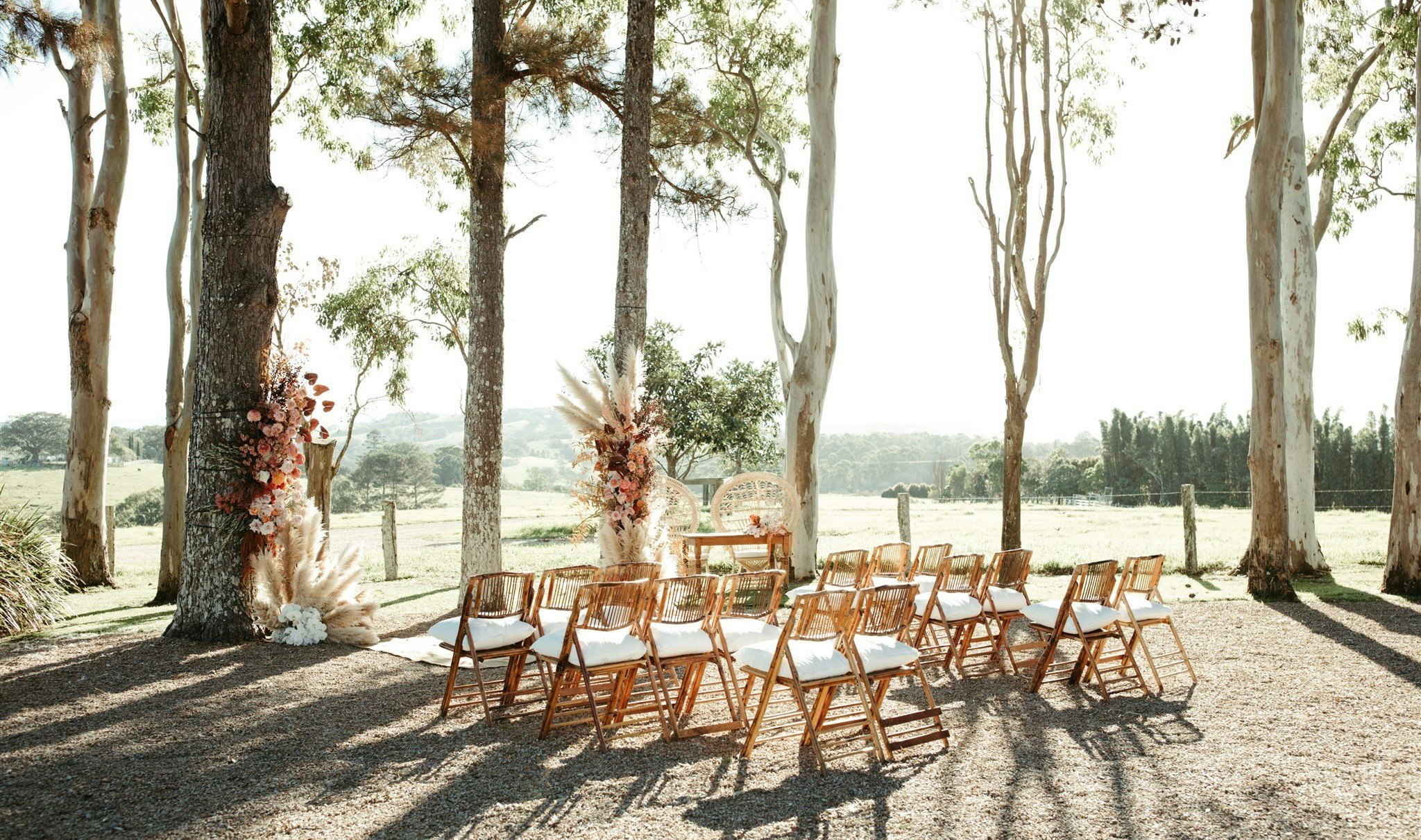 Outdoor wedding ceremony among gumtrees and floral installations.